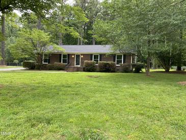 Charming brick home featuring black shutters, a well-manicured lawn, and mature trees in a serene setting at 108 Shadowbrook Dr, Hillsborough, NC 27278