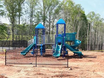 Community playground with blue and green play equipment and a black fence at 131 Siebold St, Garner, NC 27529