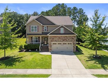 Charming two-story home featuring a stone-accented facade, well-maintained landscaping, and a two-car garage at 175 Hawkesburg Dr, Clayton, NC 27527