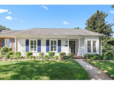 Charming home exterior with manicured lawn, blue shutters, and mature landscaping at 2617 Cottage Cir, Raleigh, NC 27613