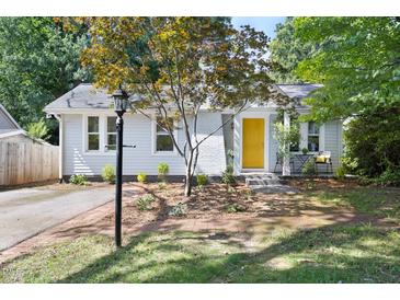 Charming single-story home featuring a bright yellow door, a brick pathway, and a well-manicured front yard at 2804 Barmettler St, Raleigh, NC 27607