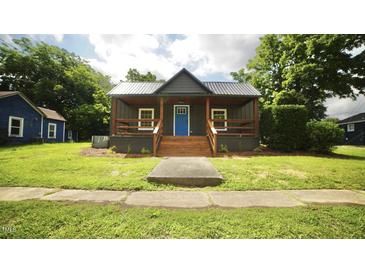 Charming home features a covered porch and a bright blue front door at 416 Everett St, Burlington, NC 27215