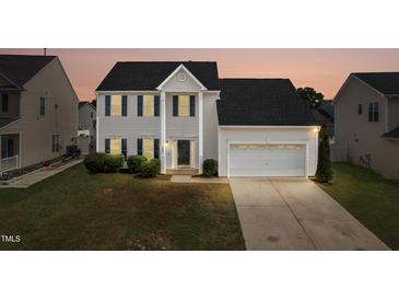 Charming two-story home with attached two-car garage, well-maintained lawn, and manicured shrubbery at 5309 Neuse Wood Dr, Raleigh, NC 27616