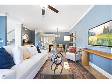 Bright living room with a white sofa, glass coffee table, and a stylish decor at 547 Forestville Rd, Wake Forest, NC 27587