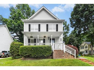 Charming two-story home with white siding, black shutters, front porch, and landscaped yard at 8513 Buscot Ct, Raleigh, NC 27615