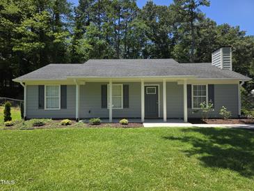 Charming single-story home with manicured lawn, inviting front porch, and light gray siding at 1016 Buckhorn Rd, Garner, NC 27529
