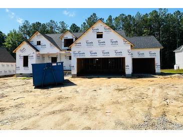View of new construction home featuring a three-car garage and Tyvek HomeWrap at 128 Seahawk Way, Zebulon, NC 27597