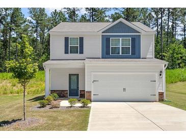 Charming two-story home with a two-car garage, stone accents, and a well-manicured lawn at 224 Ivy Bank Dr, Angier, NC 27501