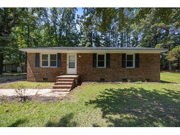 Charming one-story brick home with a well-maintained lawn and classic black shutters at 37 Weeping Willow Ln, Lillington, NC 27546