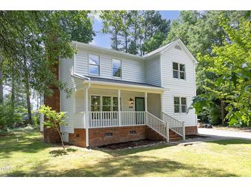 Charming two-story home with a welcoming front porch and beautifully landscaped yard at 409 Glaive Dr, Durham, NC 27703