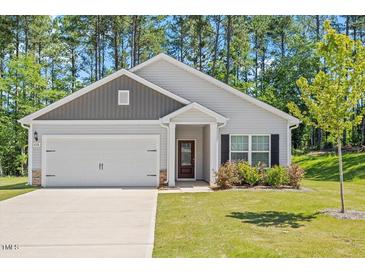 Charming single-story home with a well-manicured lawn, attached garage, and a welcoming front entrance at 418 Ivy Bank Dr, Angier, NC 27501