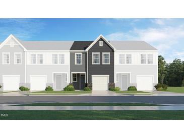 New townhome with gray siding, stone accents, and a two-car garage in a suburban neighborhood at 6015 Grey Colt Way, Durham, NC 27703