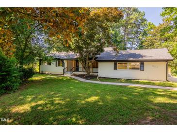 Charming one-story home with white brick exterior and landscaped front yard at 944 Athens Dr, Raleigh, NC 27606