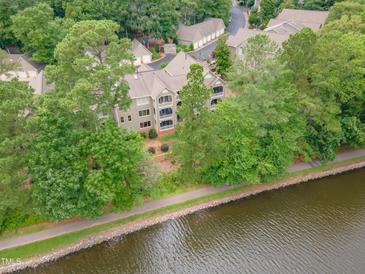 Scenic aerial view of the condo building along the water with mature trees and green foliage at 0317 Glen Echo Ln # C, Cary, NC 27518
