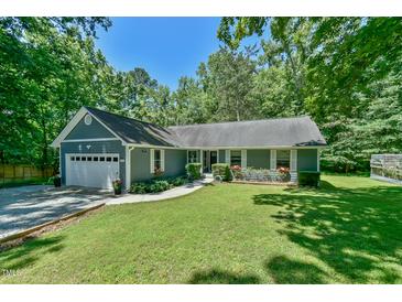Charming single-story home with a well-manicured lawn, attached garage and flowering window boxes at 1205 Hillsborough Rd, Chapel Hill, NC 27516