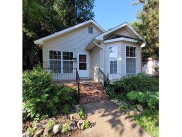 Charming single-story home with brick steps, manicured landscaping, and a welcoming front entrance at 1512 E Lane St, Raleigh, NC 27610