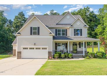 Charming two-story home with a well-maintained lawn, attached garage and inviting front porch at 1726 Rapids Ct, Franklinton, NC 27525
