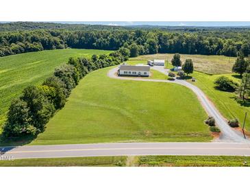 Expansive aerial view of a country home with sprawling lawn, mature trees and outbuildings at 190 Mitchells Chapel Road, Pittsboro, NC 27312
