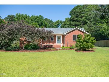 Charming brick home featuring a lush lawn and mature trees in a desirable neighborhood at 1975 Oakridge Duncan Rd, Fuquay Varina, NC 27526