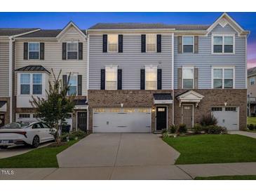 Charming townhome with brick facade, attached garage, and well-maintained landscaping at 333 Amber Acorn Ave, Raleigh, NC 27603