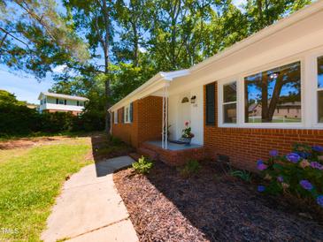 Charming brick home featuring manicured landscaping and a welcoming entrance at 438 N Hickory St, Angier, NC 27501