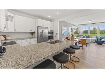 Modern kitchen features stainless steel appliances, granite countertops, and a breakfast bar with seating at 509 Kildaire Farm Rd # 101, Cary, NC 27511