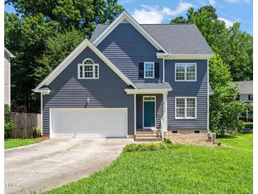 Charming two-story home with blue siding, white trim, two car garage, and well-manicured lawn at 9508 Waterwood Ct, Raleigh, NC 27614