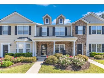 Charming townhome exterior featuring a stone facade, dormer windows and manicured landscaping at 1725 T W Alexander Dr # 204, Durham, NC 27703