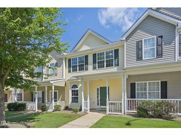 Inviting two-story townhome with green front door and charming front porch and well-manicured lawn at 3973 Volkswalk Pl, Raleigh, NC 27610