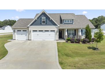 Charming home with a spacious three-car garage and well-maintained front yard at 50 N Nolan Park Dr, Selma, NC 27576