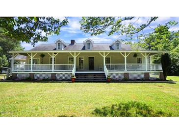 Charming home with a covered porch, dormer windows, and lush green lawn at 6600 Sadie Dr, Wendell, NC 27591