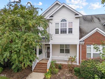 Charming two-story townhouse featuring a classic white facade, brick accents, and a welcoming front porch at 1012 Palace Garden Way, Raleigh, NC 27603