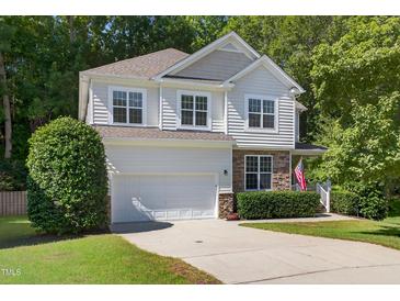 Charming two-story home features a stone facade, attached garage, and an inviting, landscaped front yard at 1437 Lindenberg Sq, Wake Forest, NC 27587