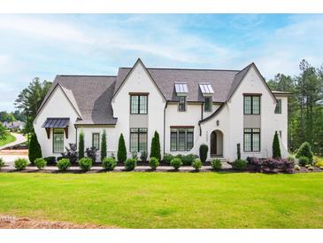 Stunning two-story painted brick home with professionally landscaped front yard and beautiful architectural details at 7304 Wexford Woods Ln, Wake Forest, NC 27587