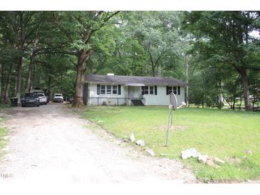 Charming single-story home with a well-maintained lawn and mature trees offering shade at 908 Valmet Dr, Durham, NC 27703