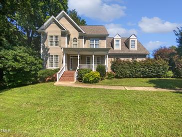 Charming two-story home with a welcoming front porch and manicured lawn at 2408 Tiltonshire Ln, Apex, NC 27539