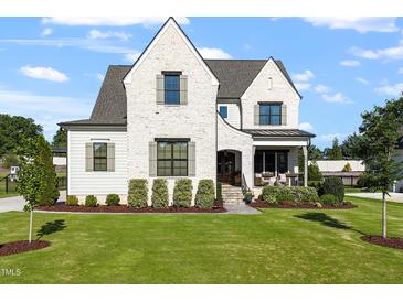 Beautiful white brick home with manicured lawn and professional landscaping at 241 Teague St, Wake Forest, NC 27587
