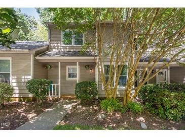 Charming home featuring a well-maintained exterior, lush landscaping, and a welcoming entrance adorned with potted flowers at 303 Applecross Dr, Cary, NC 27511