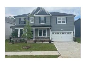 Charming two-story home with gray siding, a well-manicured lawn, and a two-car garage at 3509 Bailey Lake Dr, Fuquay Varina, NC 27526