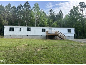 View of home with front yard, showing the wooden deck and stairs at 4025 Royal Dr, Franklinton, NC 27525