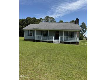 Charming single story home features a covered porch and lush green lawn at 410 Carmil Dr, Selma, NC 27576