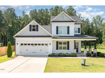 Charming two-story home with white siding, black shutters, a two-car garage, and a well-manicured lawn at 454 Martins Mill Ct, Wendell, NC 27591