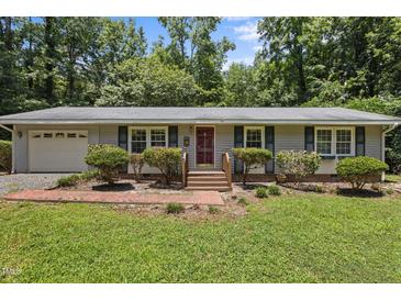 Charming single-story home featuring a brick pathway, well-manicured lawn, and an inviting red front door at 18 Red Pine Rd, Chapel Hill, NC 27516