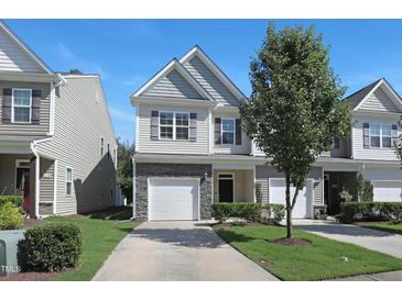 Inviting two-story home featuring a one-car garage, stone accents, and professionally maintained landscaping at 3636 Water Mist Ln, Raleigh, NC 27604