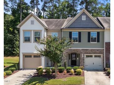 Charming two-story townhome with stone accents, attached garages, and a well-maintained lawn at 3810 Prince Noah Loop, Wake Forest, NC 27587