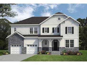 Charming two-story home featuring stone accents, a covered porch, and a well-manicured lawn at 56 Alex Farm Ct # 24, Zebulon, NC 27597