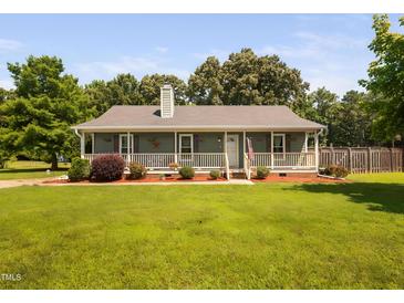 Charming ranch-style home featuring a welcoming front porch, tidy landscaping, and a lush green lawn at 73 Richmond Dr, Archer Lodge, NC 27527