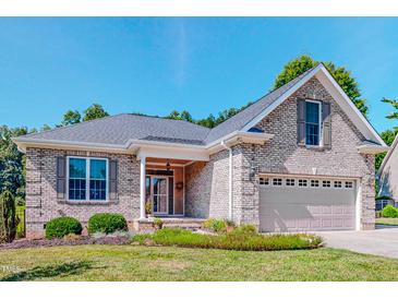 Charming single-Gathering home featuring a brick facade, well-manicured lawn, and attached two-car garage at 90 S Old Lantern Rd, Timberlake, NC 27583