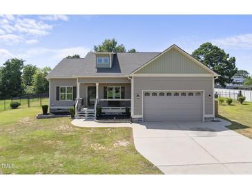 Charming single-Gathering home featuring a two-car garage, covered front porch, and well-maintained lawn at 172 Fox Run Ct, Benson, NC 27504