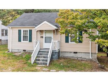 Charming single-story home featuring beige siding, green shutters, and a cozy front porch at 203 Spring Street St, Louisburg, NC 27549
